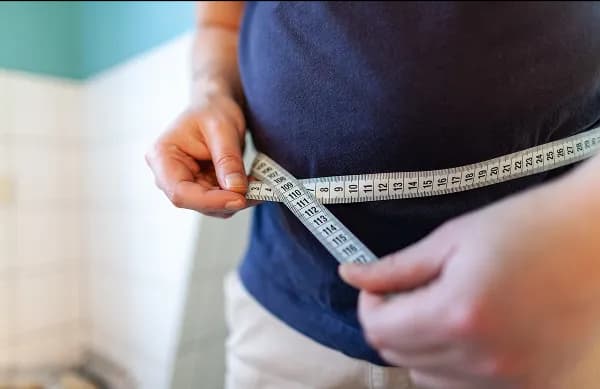 Close-up of a person measuring their waist