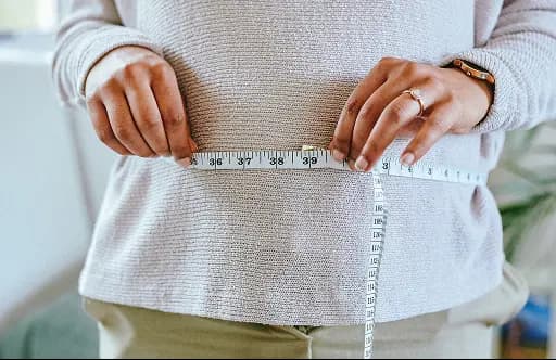 Woman measuring her waist
