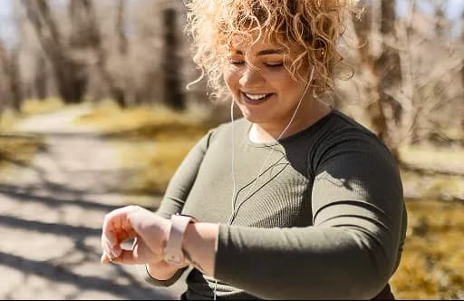 Smiling woman looking at smart watch