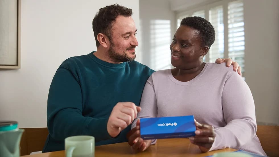 Couple at home discussing care with medication packaging
