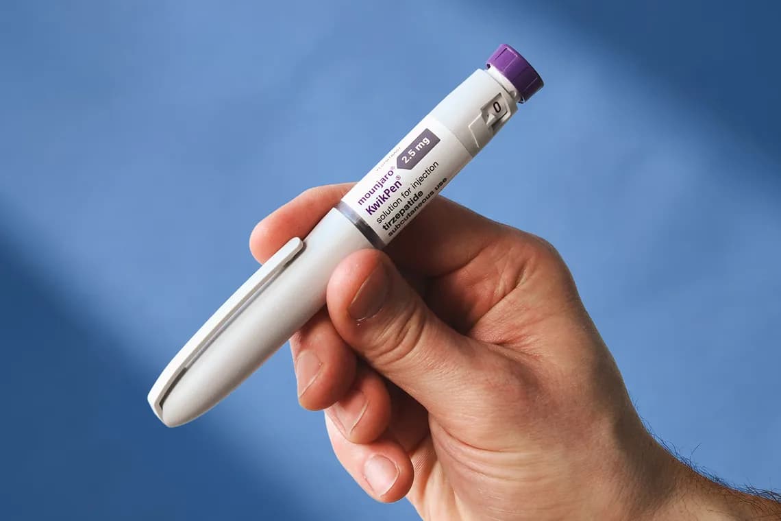 A GLP-1 pen held in a hand