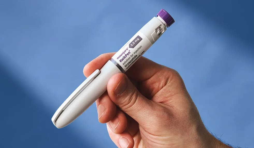A GLP-1 pen held in a hand