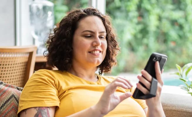 A smiling woman on her phone