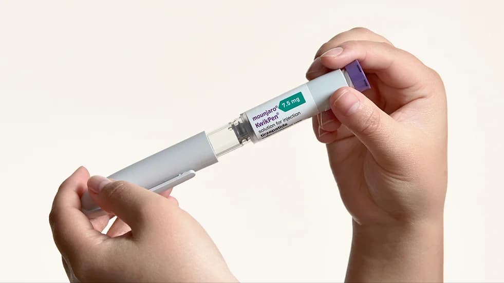 Hands holding a Mounjaro injection pen