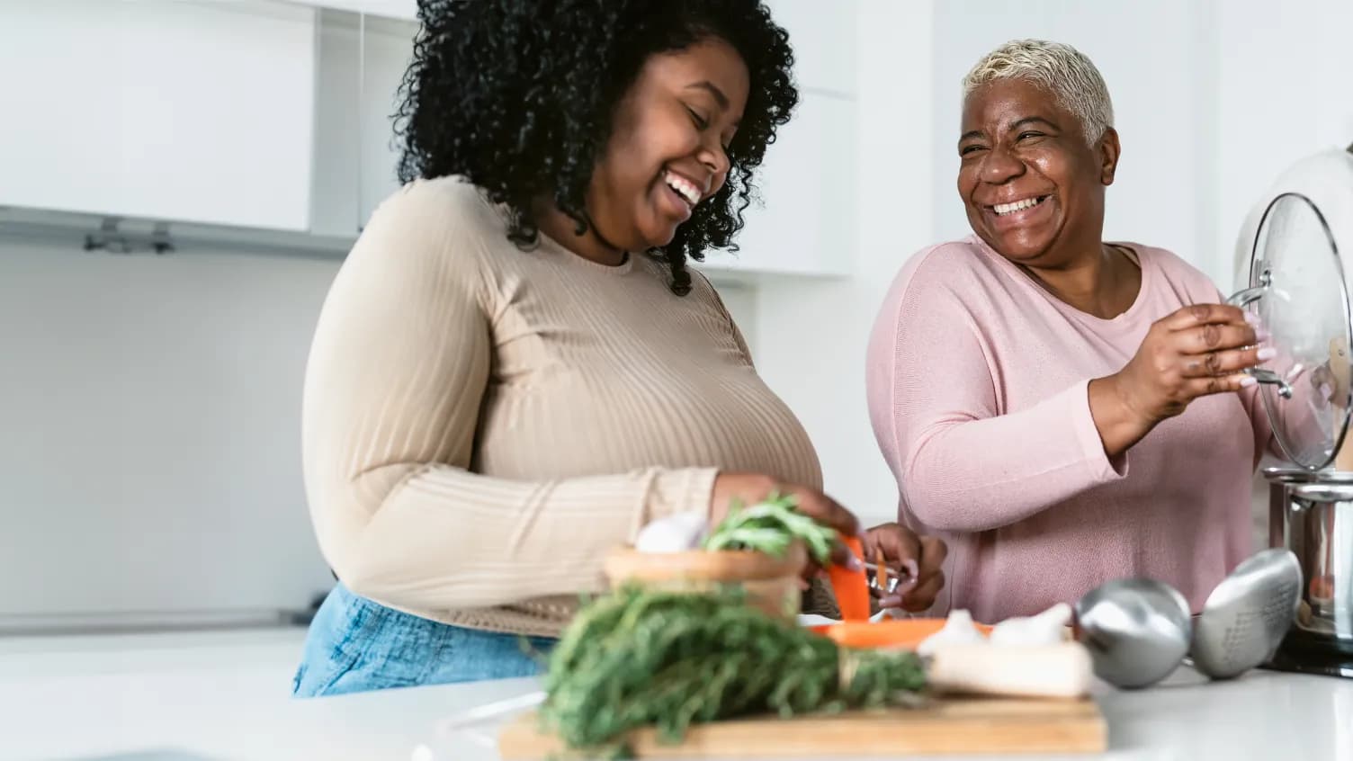 Two people cooking together and sharing a laugh
