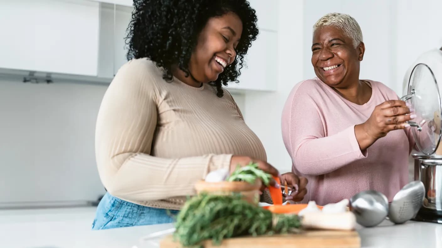 Two people cooking together and sharing a laugh