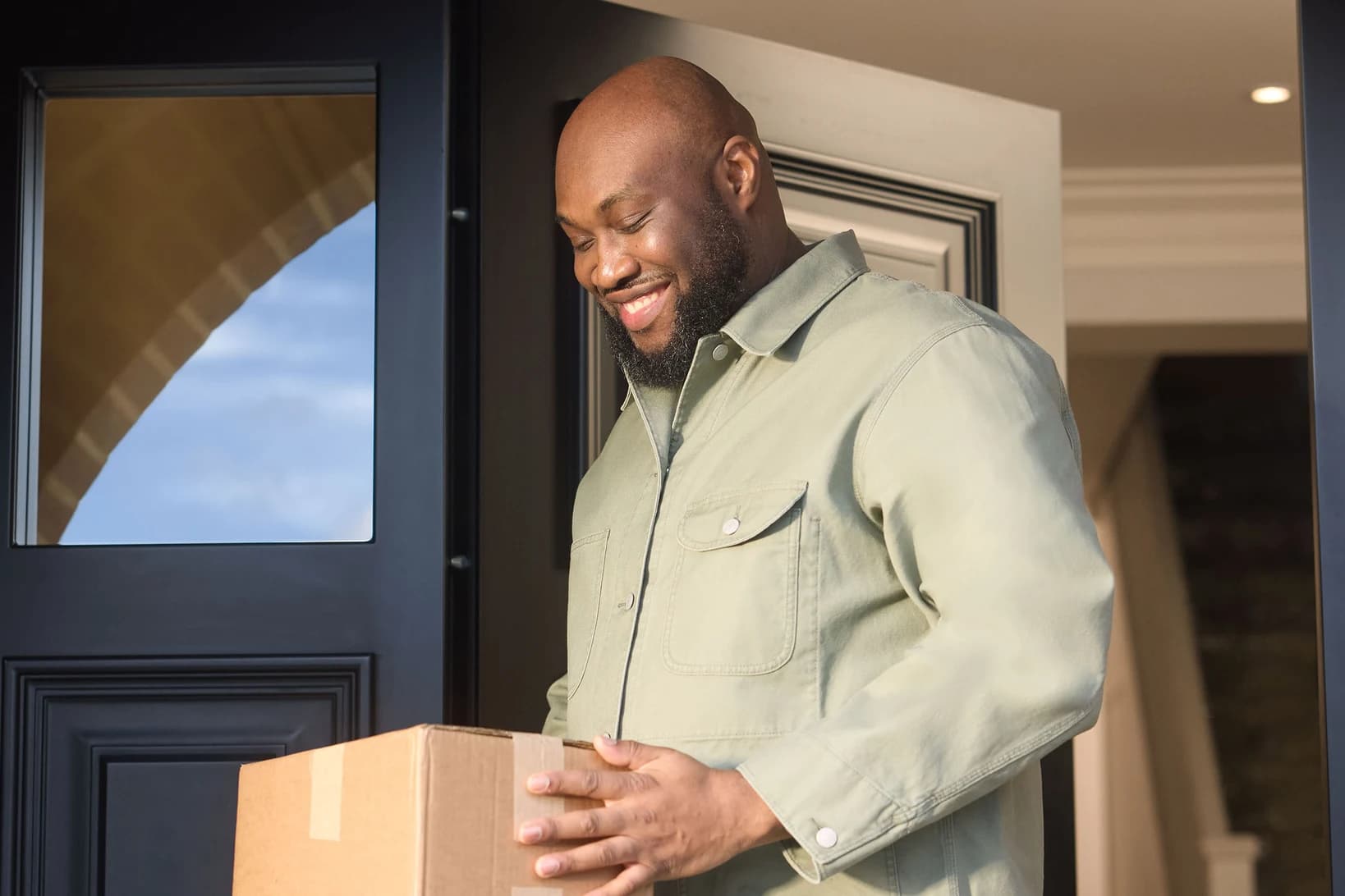 Man holding a MedExpress delivery box at his front door