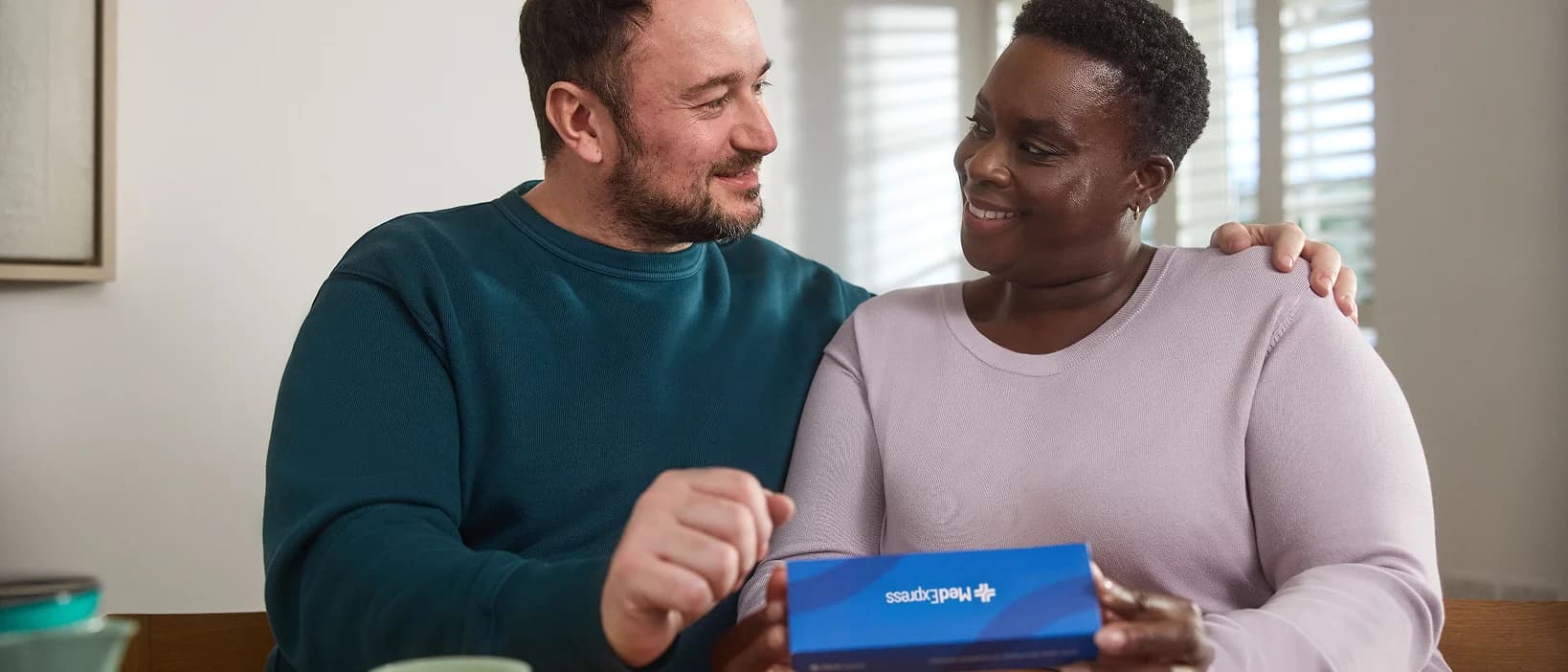 A couple reviewing a MedExpress delivery box together