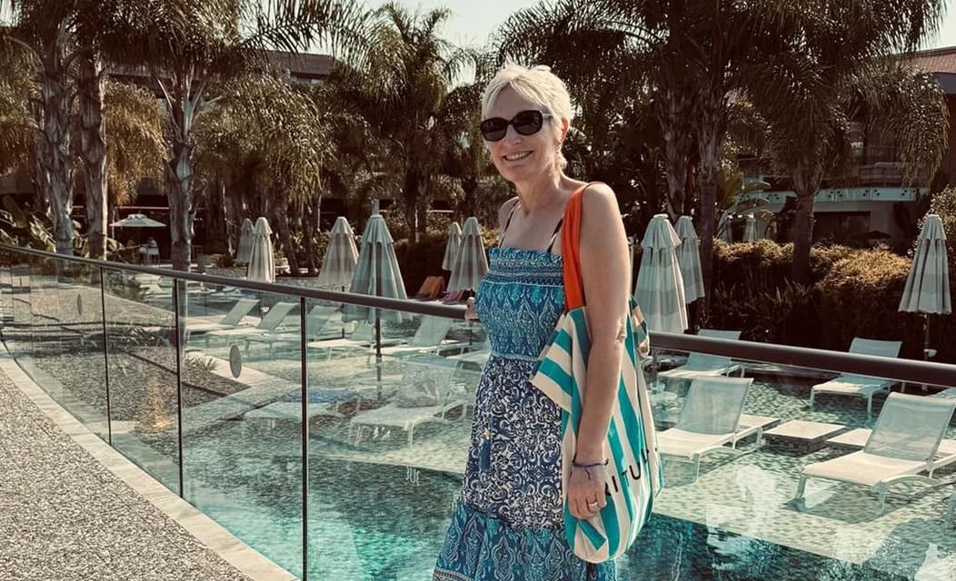 A woman standing beside a hotel pool